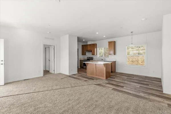 a large white kitchen with kitchen island a sink stainless steel appliances and cabinets