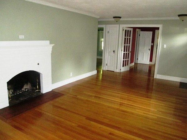 9 Alden Road Needham, MA 02492 - Photo 3 of 16 a view of an empty room with wooden floor and a fireplace