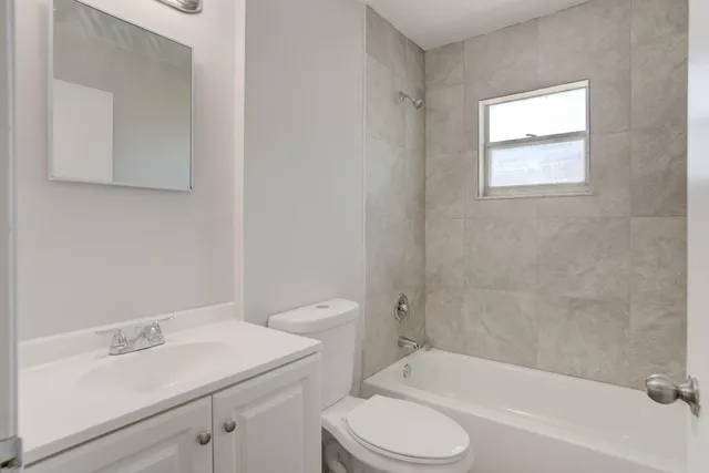 a bathroom with a sink toilet vanity and bathtub