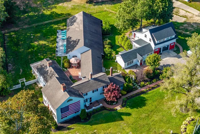 an aerial view of a house with swimming pool a patio and yard