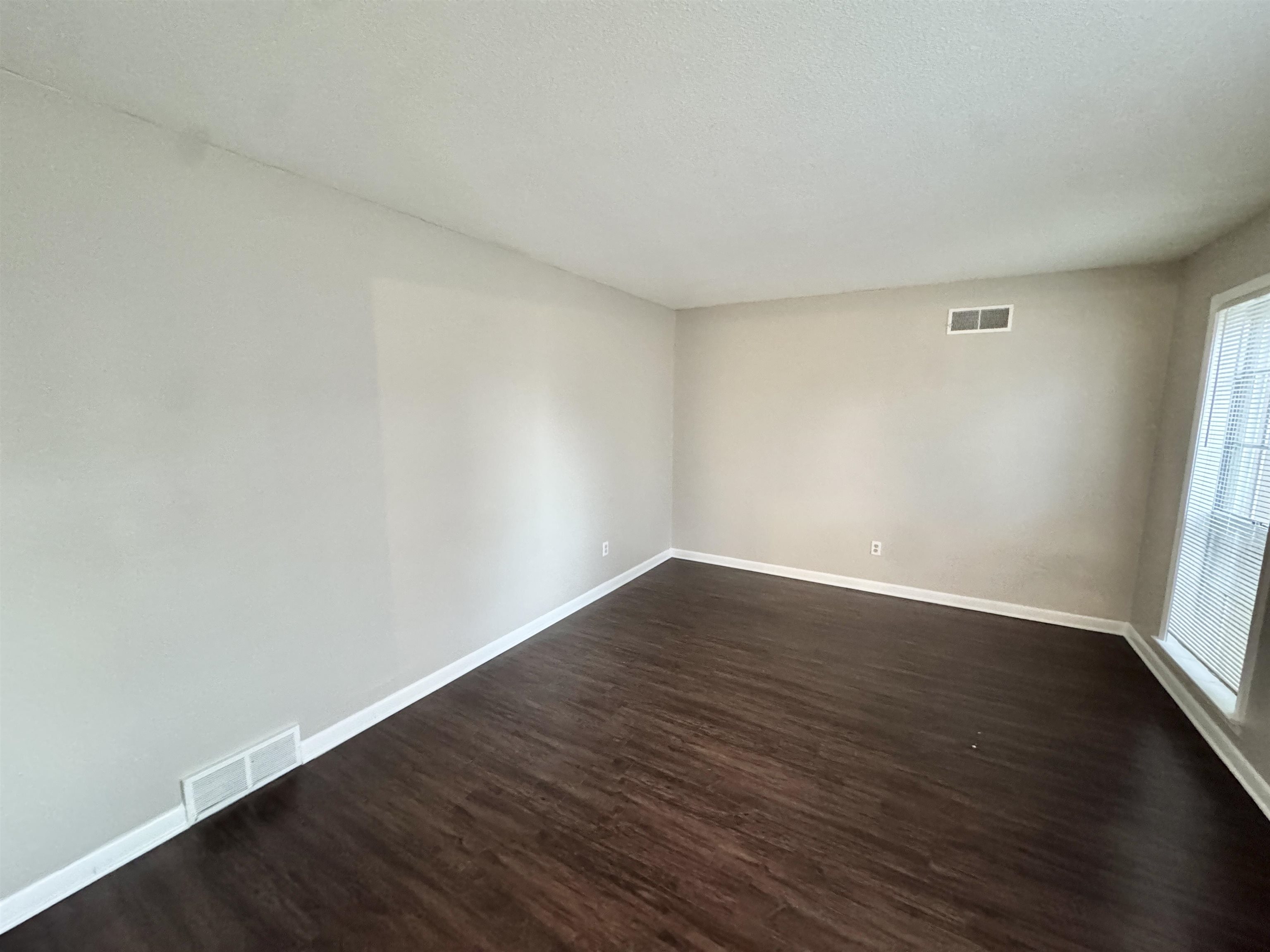 3174 Emerald Street Memphis, TN 38115 - Photo 13 of 28 a view of an empty room with wooden floor and a window