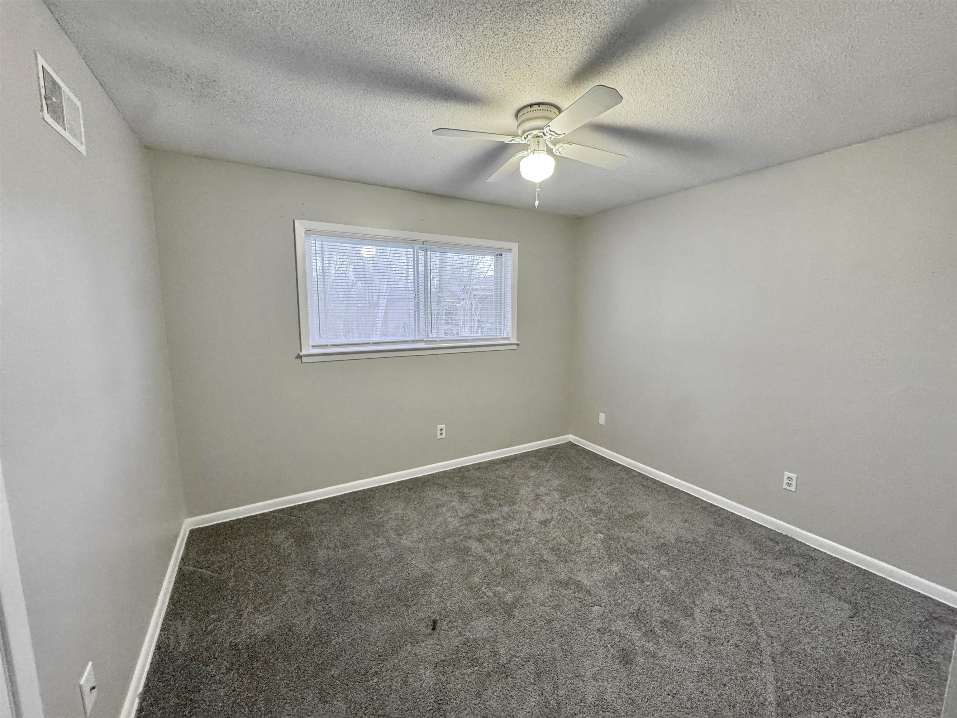 3174 Emerald Street Memphis, TN 38115 - Photo 14 of 28 an empty room with a chandelier fan and windows