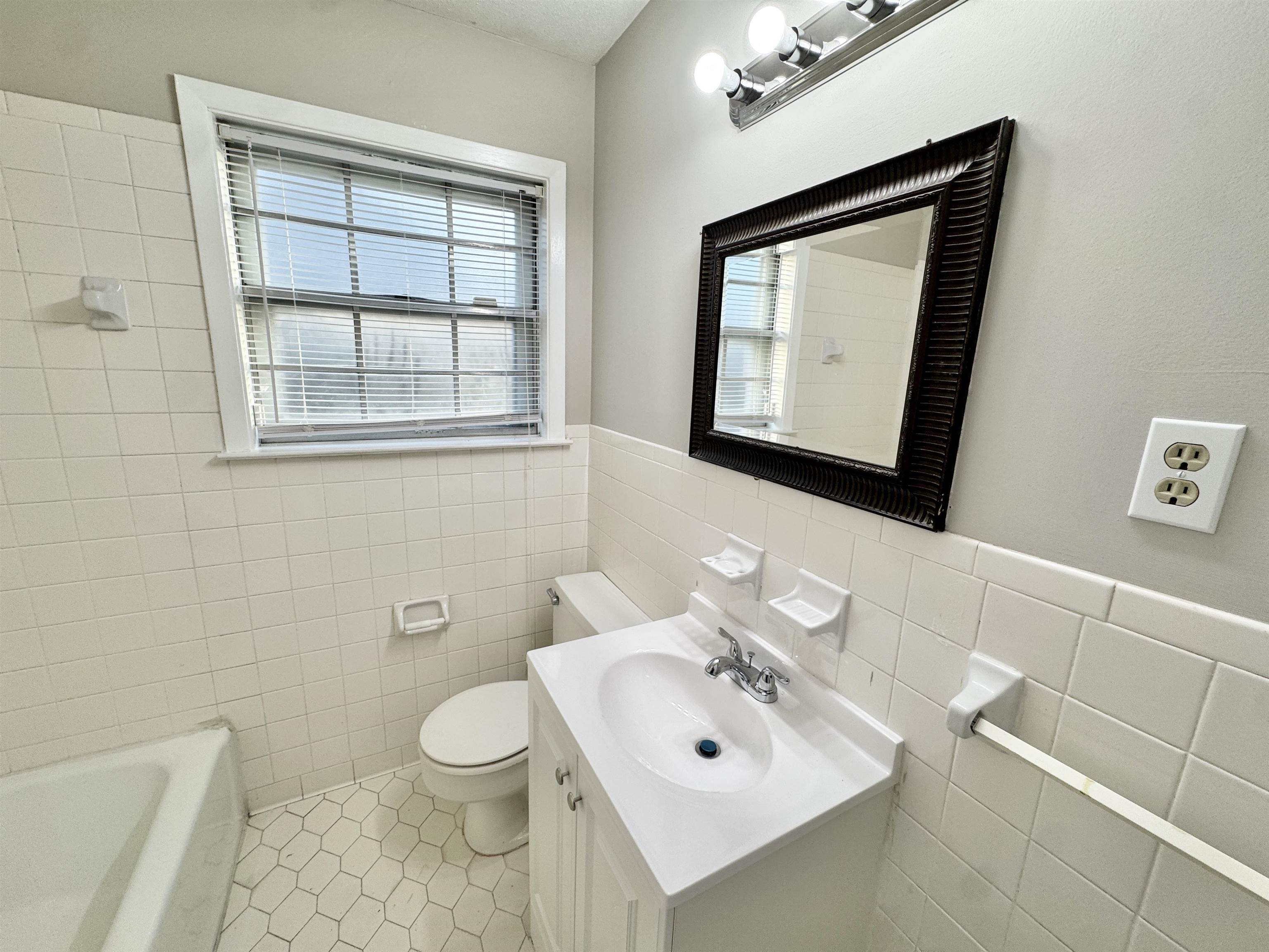 3174 Emerald Street Memphis, TN 38115 - Photo 18 of 28 a bathroom with a toilet a sink and mirror