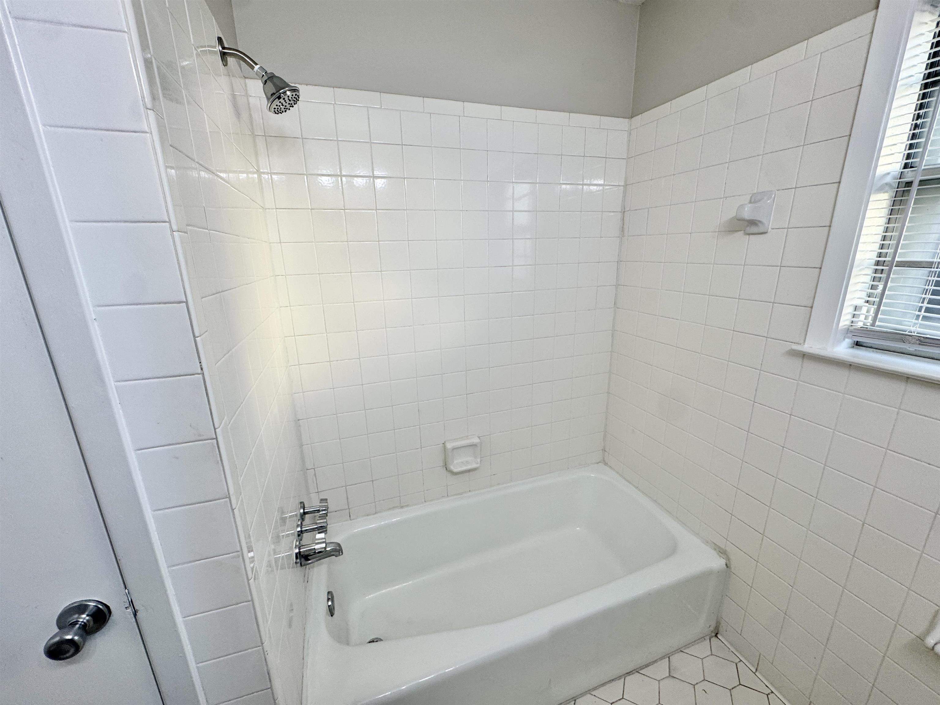 3174 Emerald Street Memphis, TN 38115 - Photo 19 of 28 a white bath tub and shower in a bathroom