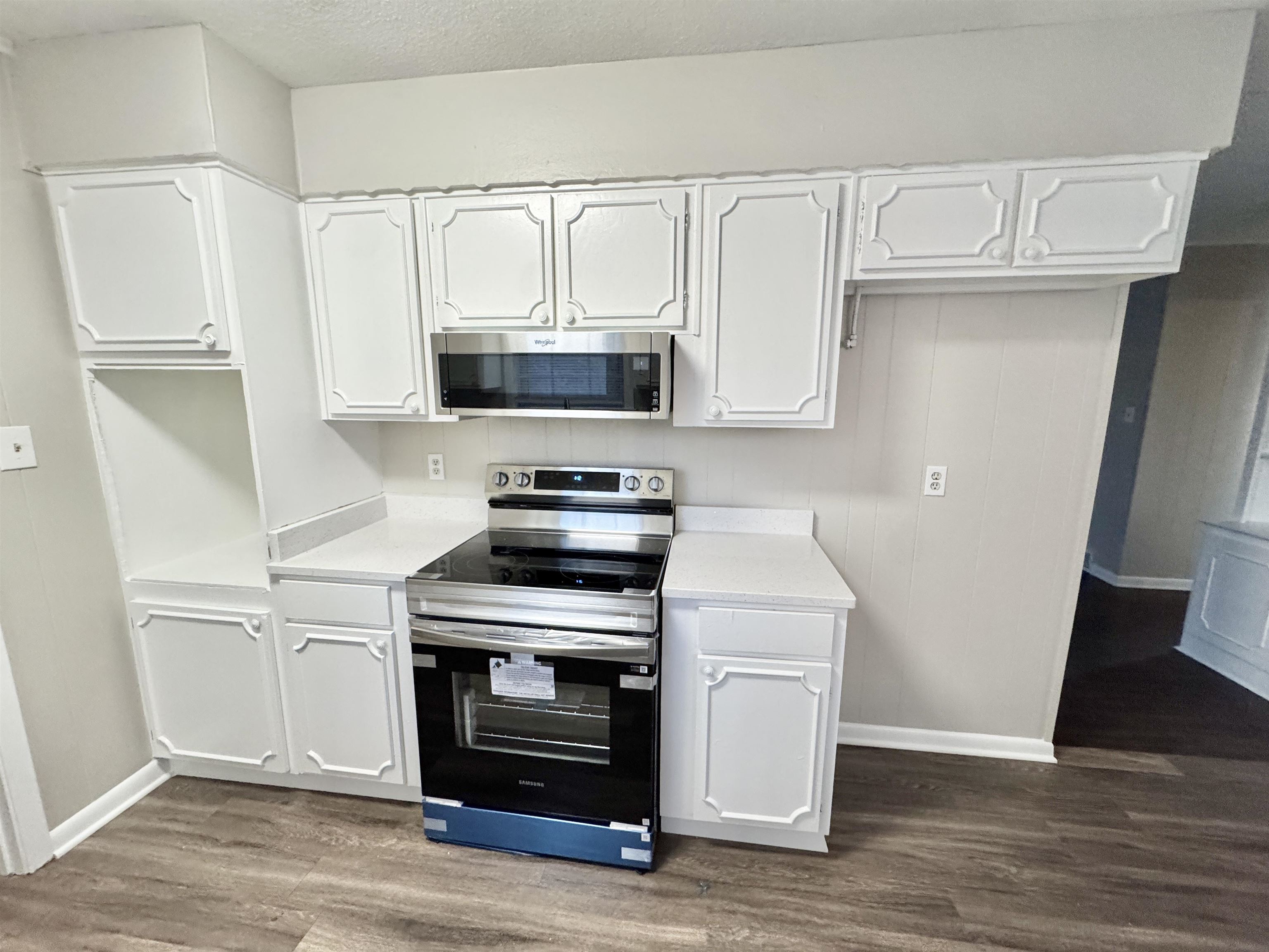 3174 Emerald Street Memphis, TN 38115 - Photo 3 of 28 a kitchen with white cabinets and stainless steel appliances