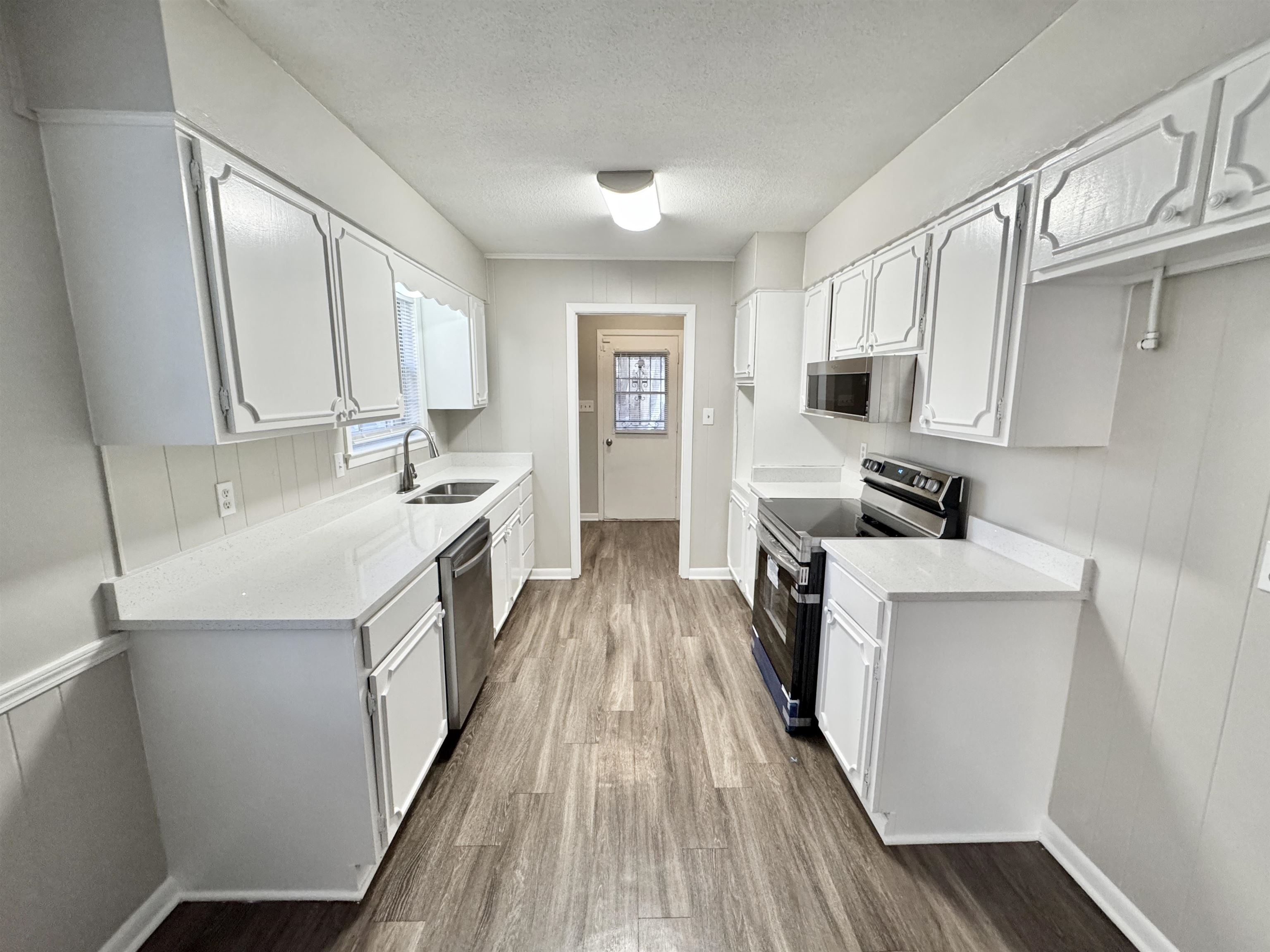 3174 Emerald Street Memphis, TN 38115 - Photo 4 of 28 a kitchen with a sink a counter top space stainless steel appliances a window and a counter top space