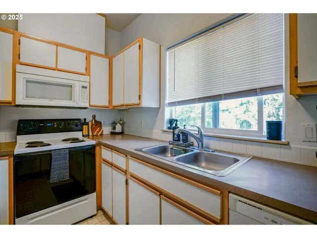 a kitchen with stainless steel appliances granite countertop a sink a stove and a microwave