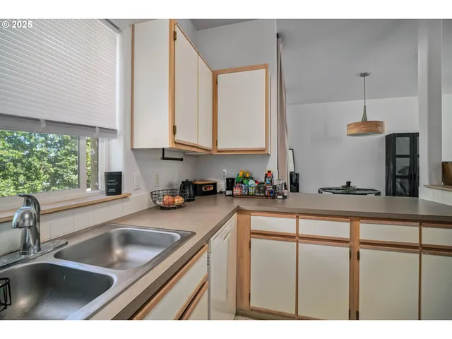 a kitchen with kitchen island granite countertop a sink stainless steel appliances and cabinets