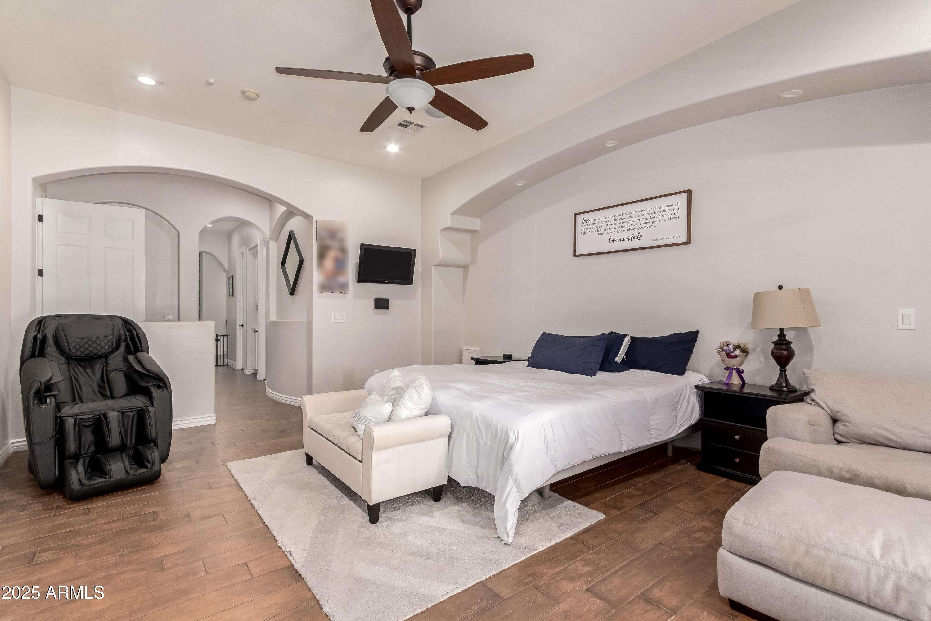 4584 East Reins Road Gilbert, AZ 85297 - Photo 19 of 58 a spacious bedroom with a bed a couch and a chandelier