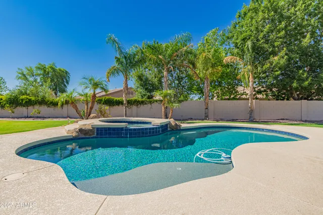 an aerial view of a house with swimming pool and large trees