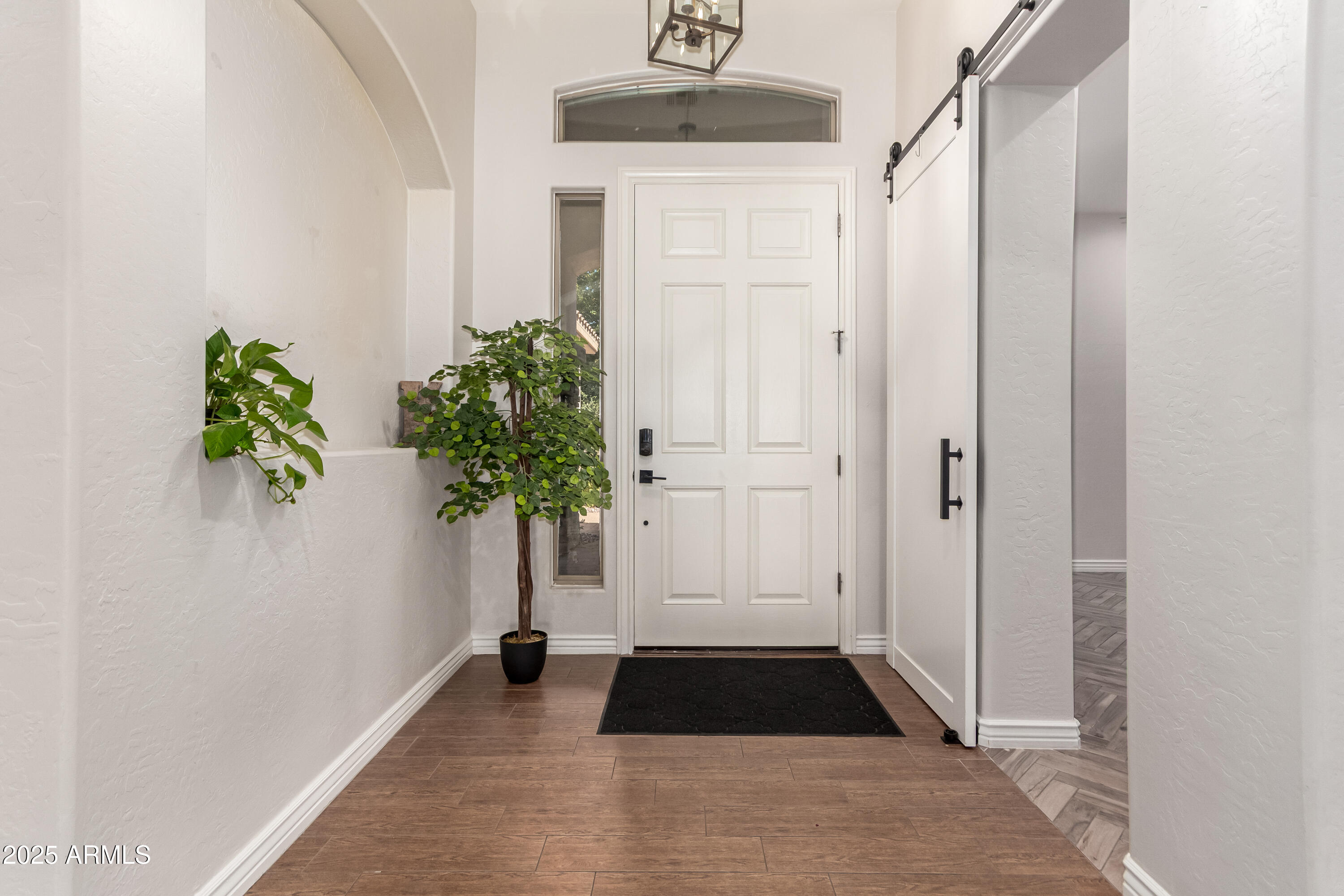 4584 East Reins Road Gilbert, AZ 85297 - Photo 6 of 58 a view of a hallway with wooden floor and a potted plant