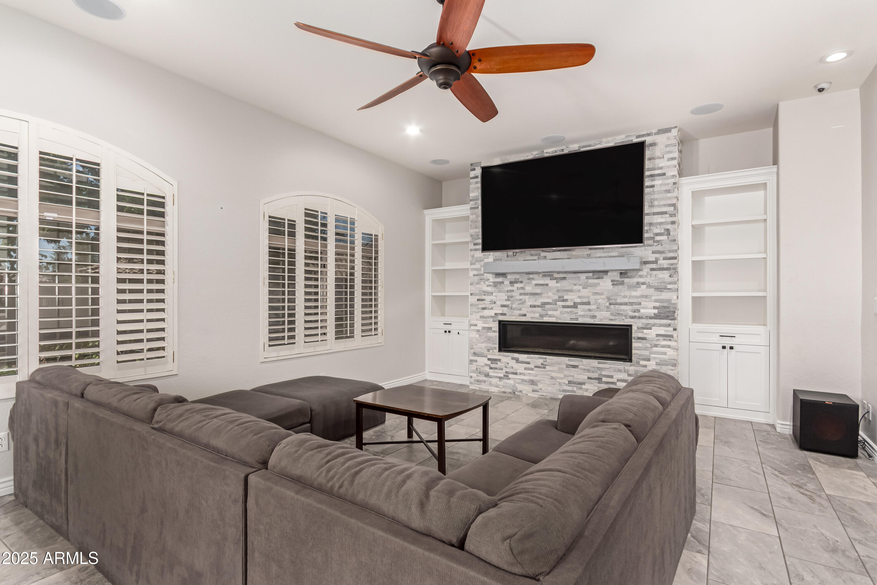 4584 East Reins Road Gilbert, AZ 85297 - Photo 9 of 58 a living room with furniture a flat screen tv and a fireplace