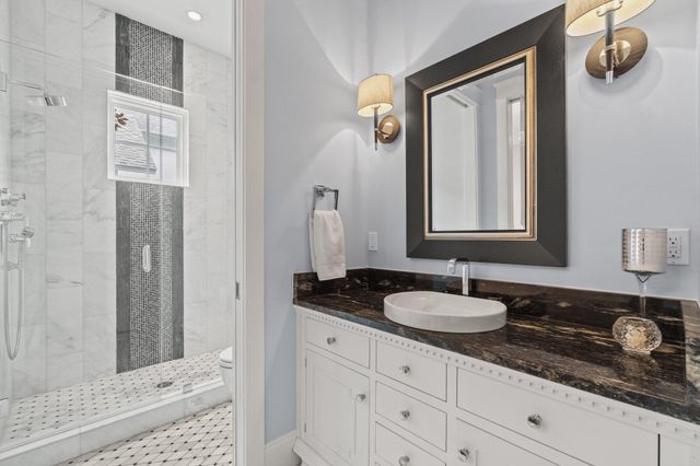 a bedroom with a bed and a lamp on dresser