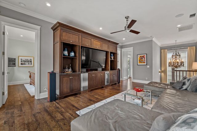 a living room with furniture a flat screen tv and wooden floor