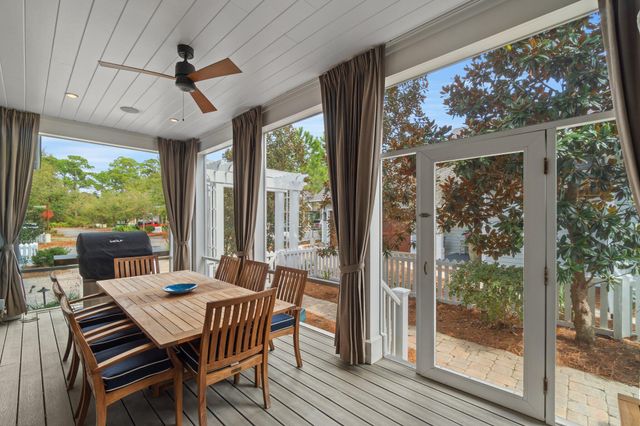 a living room with patio furniture and a floor to ceiling window