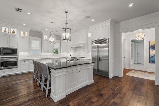 a kitchen with stainless steel appliances granite countertop a table and stove top oven
