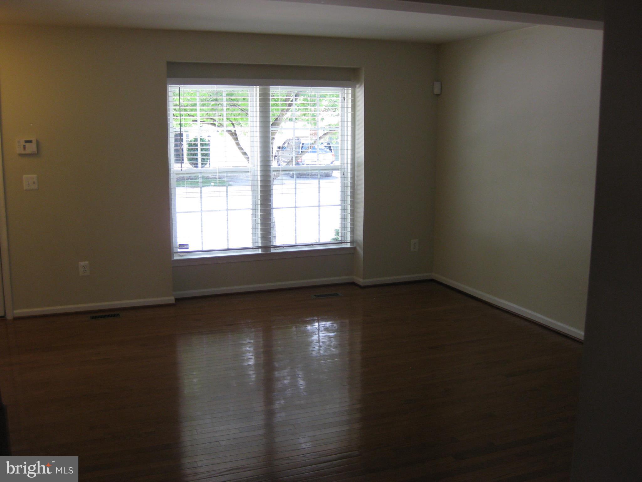1252 Steed Street Ranson, WV 25438 - Photo 13 of 36 a view of an empty room with wooden floor and a window