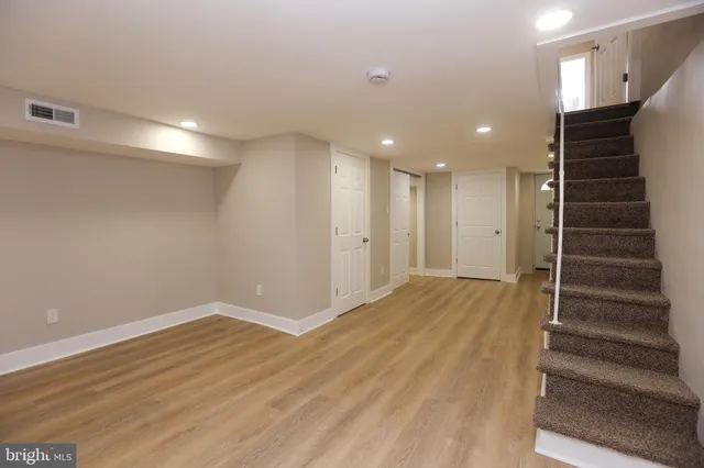 a view of hallway with stairs and wooden floor
