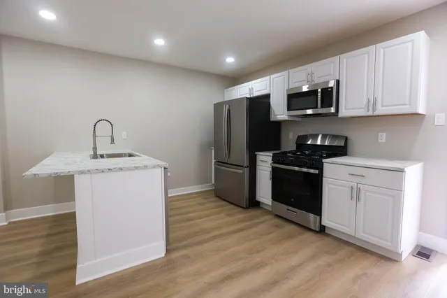 a kitchen with stainless steel appliances granite countertop a refrigerator sink and microwave