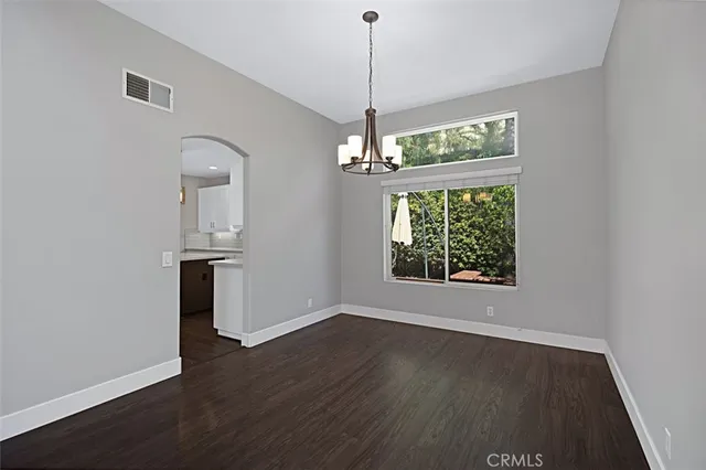 a view of a room with wooden floor a ceiling fan and a window