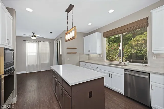 a kitchen with a sink stove and wooden floor