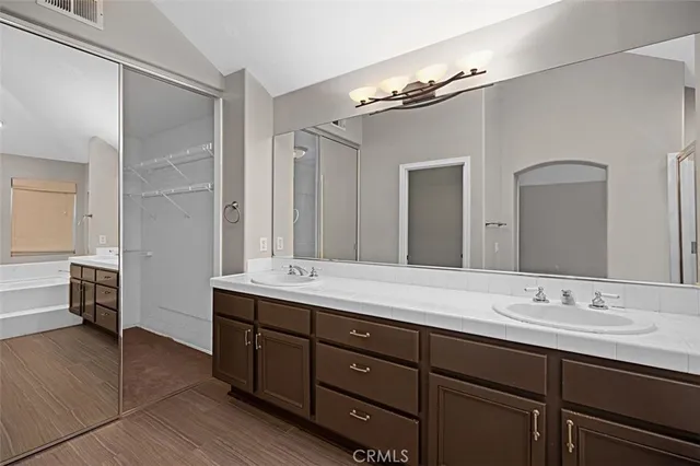 a bathroom with a tub sink and mirror