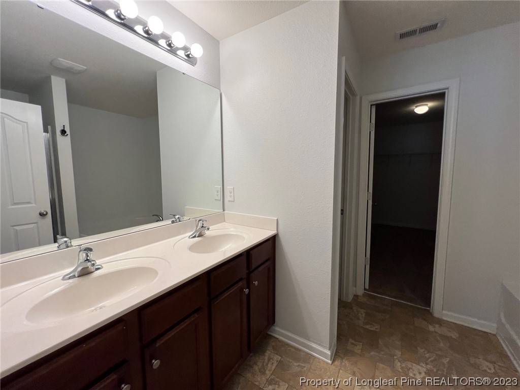 251 Botanical Court Bunnlevel, NC 28323 - Photo 16 of 20 a bathroom with a double vanity sink and a mirror