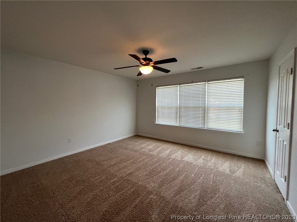 251 Botanical Court Bunnlevel, NC 28323 - Photo 10 of 20 an empty room with windows and ceiling fan