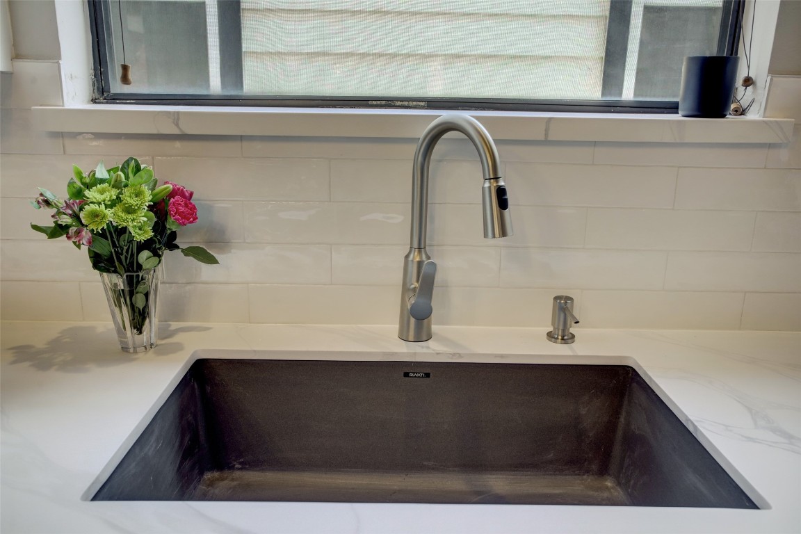 910 Malone Street, Unit 104 Houston, TX 77007 - Photo 16 of 44 Gunmetal farmhouse sink and subway tile backsplash elegantly set against the quartz countertops