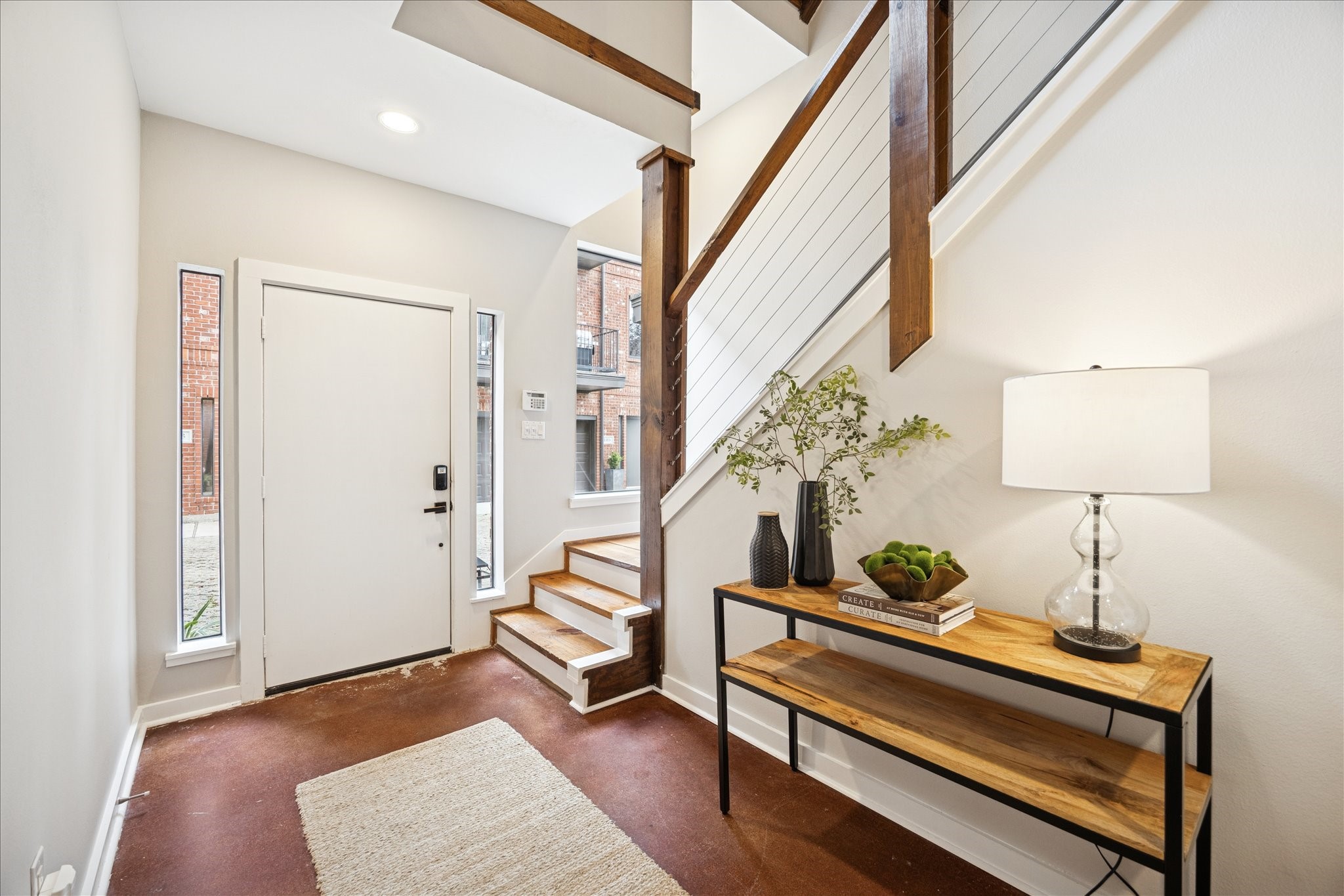 910 Malone Street, Unit 104 Houston, TX 77007 - Photo 7 of 44 Spacious foyer with sleek stained concrete floors and a modern staircase featuring cable wire banisters