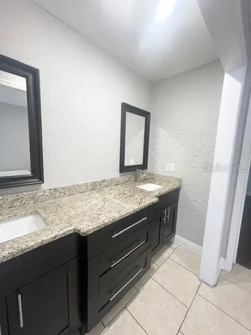 a bathroom with a granite countertop sink and a mirror