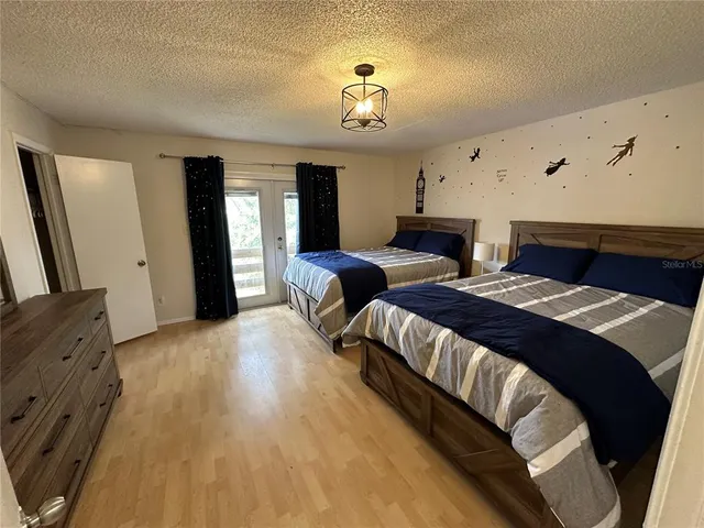 a spacious bedroom with two beds and a chandelier