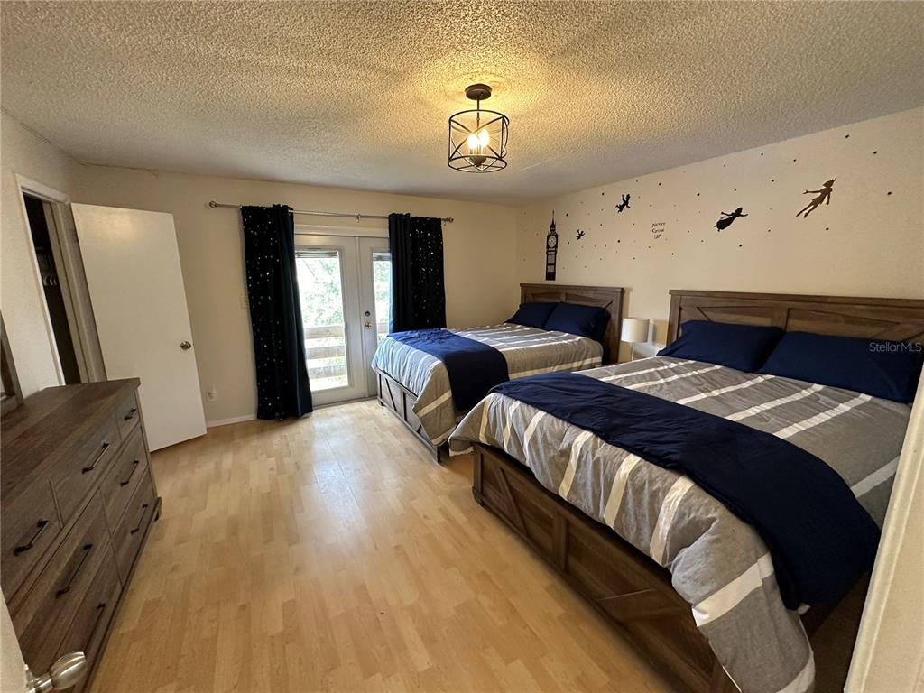 7429 Daniel Webster Drive, Unit 14 (#C) Winter Park, FL 32792 - Photo 11 of 15 a spacious bedroom with two beds and a chandelier