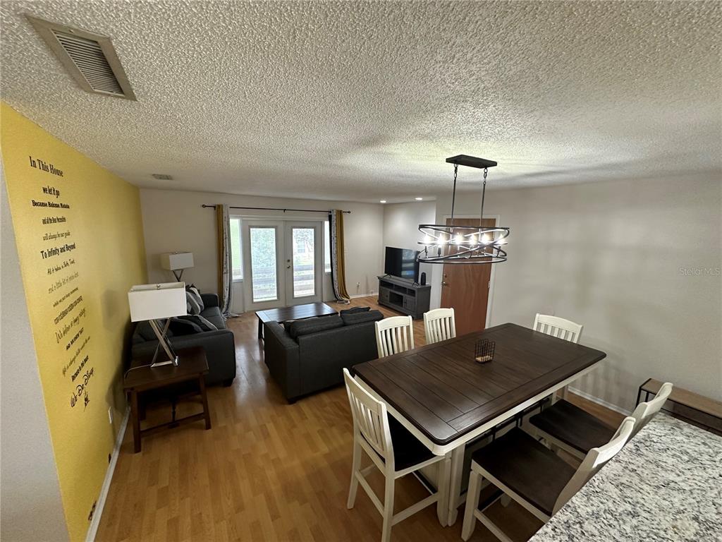 7429 Daniel Webster Drive, Unit 14 (#C) Winter Park, FL 32792 - Photo 2 of 15 a living room with furniture a chandelier and a table