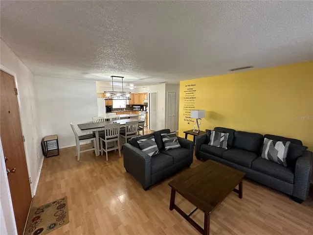 a living room with furniture and a dining table with rug