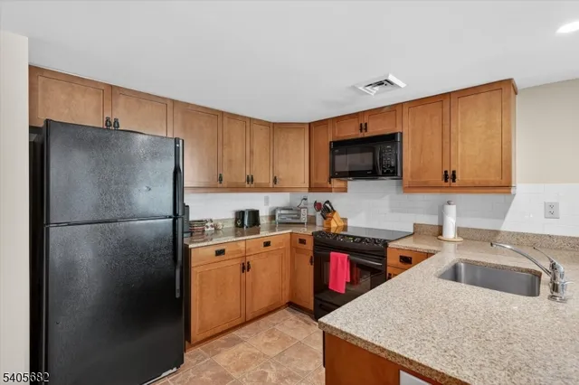 a kitchen with stainless steel appliances granite countertop a refrigerator and a stove top oven