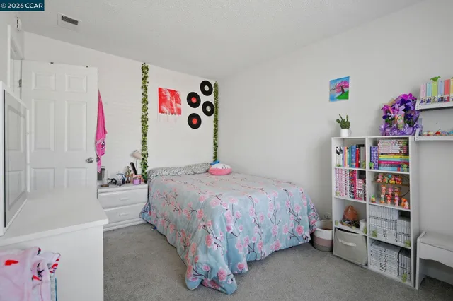 a bedroom with a bed and a white comforter