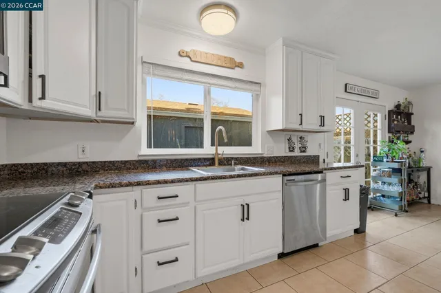 a kitchen with granite countertop a sink stainless steel appliances and cabinets