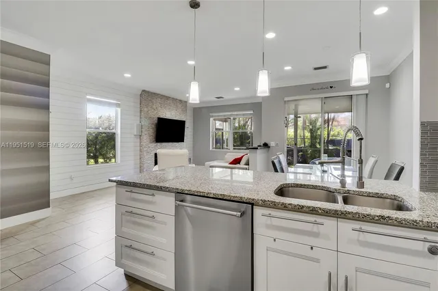 a kitchen with granite countertop a sink and a refrigerator