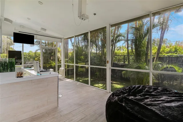 a living room with furniture tv and a floor to ceiling window