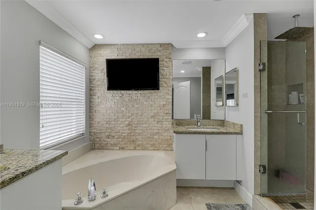 a bathroom with a granite countertop sink and a bathtub