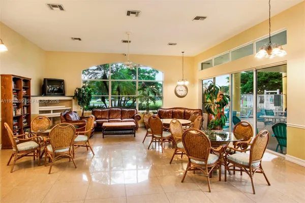 a living room with furniture a flat screen tv and a large window
