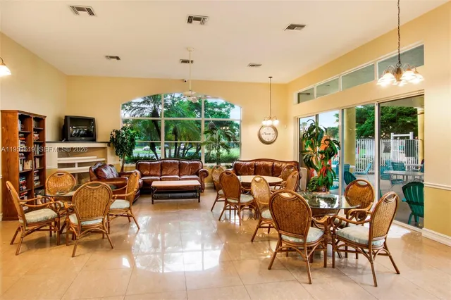 a living room with furniture a flat screen tv and a large window