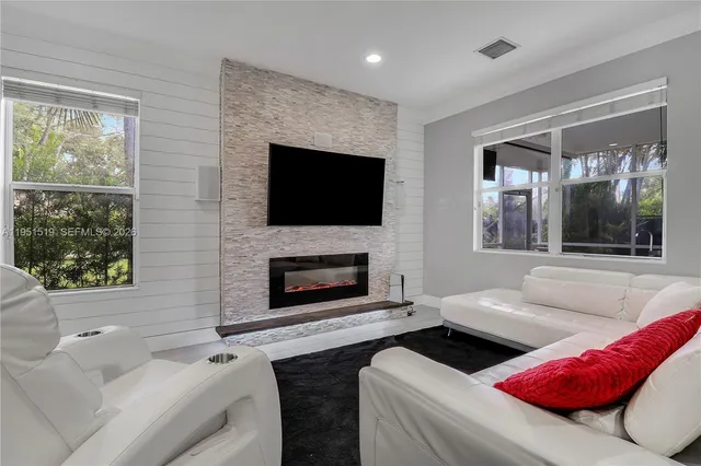 a living room with furniture a flat screen tv and a fireplace