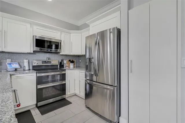 a kitchen with stainless steel appliances a refrigerator stove and microwave
