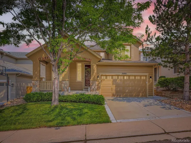 a front view of a house with a garden and garage