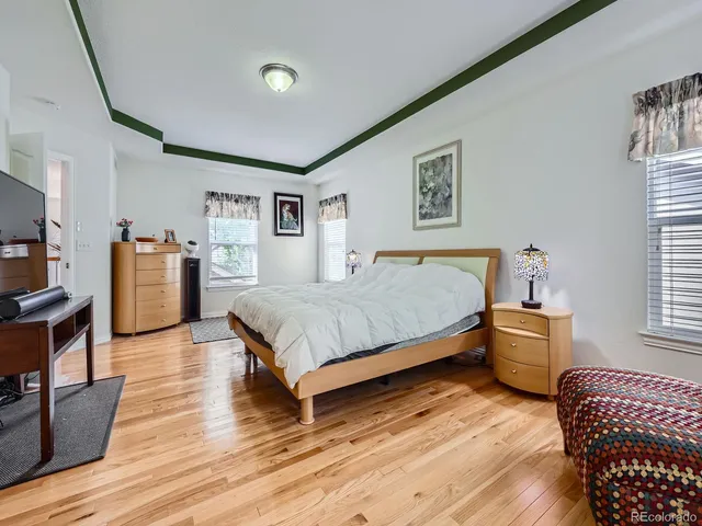 a bedroom with a bed and furniture with wooden floor