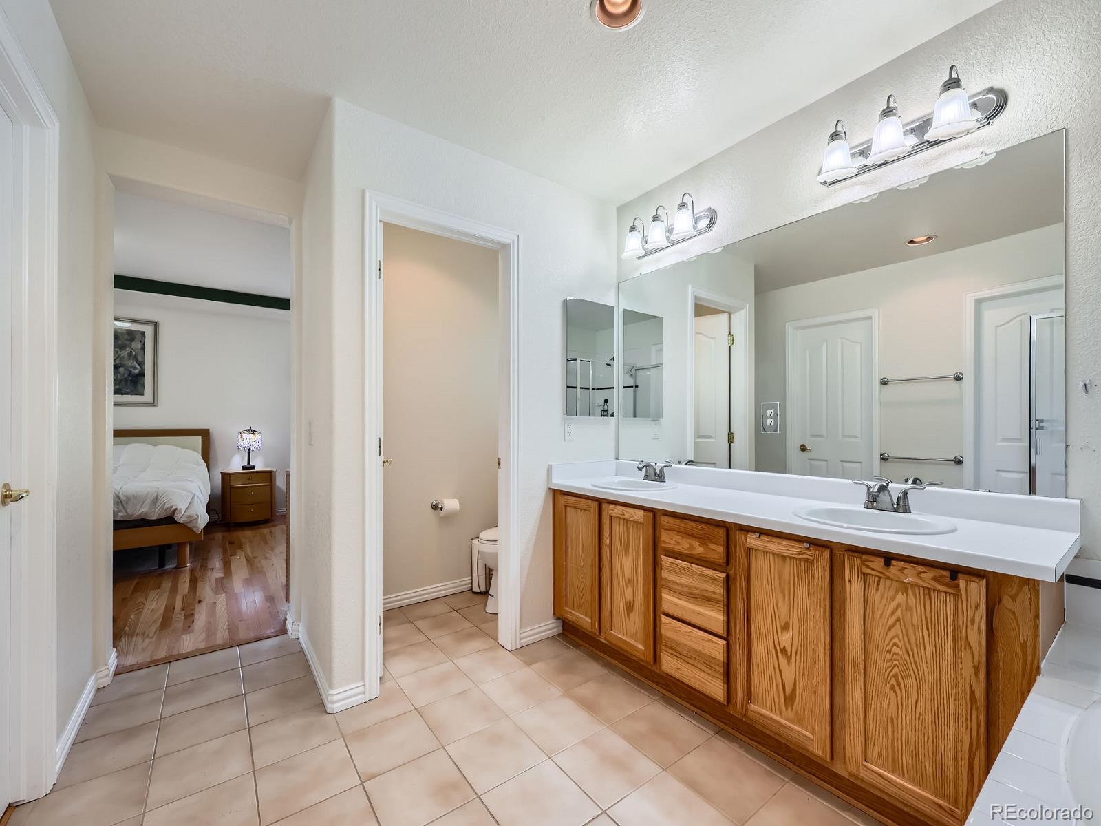 3000 Fox Sedge Lane Highlands Ranch, CO 80126 - Photo 15 of 33 a spacious bathroom with a double vanity sink a mirror and a bathtub