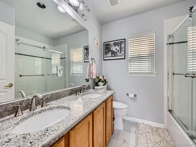 a bathroom with a granite countertop sink toilet and shower