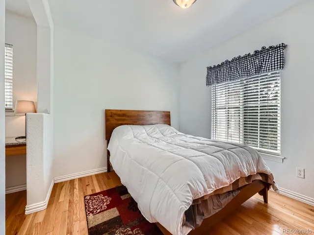 a bedroom with a bed and wooden floor
